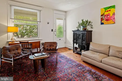 a living room with furniture a rug and a window