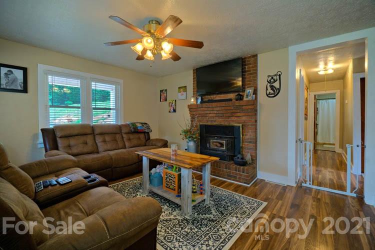 1943 Beaverdam Road Canton, NC 28716 - Photo 2 of 31 a living room with furniture a fireplace and a flat screen tv