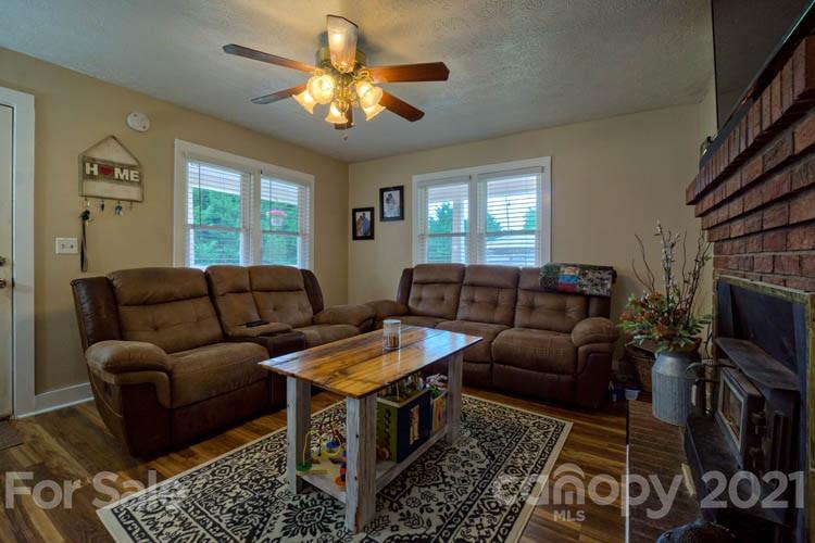 1943 Beaverdam Road Canton, NC 28716 - Photo 3 of 31 a living room with furniture a chandelier and a flat screen tv