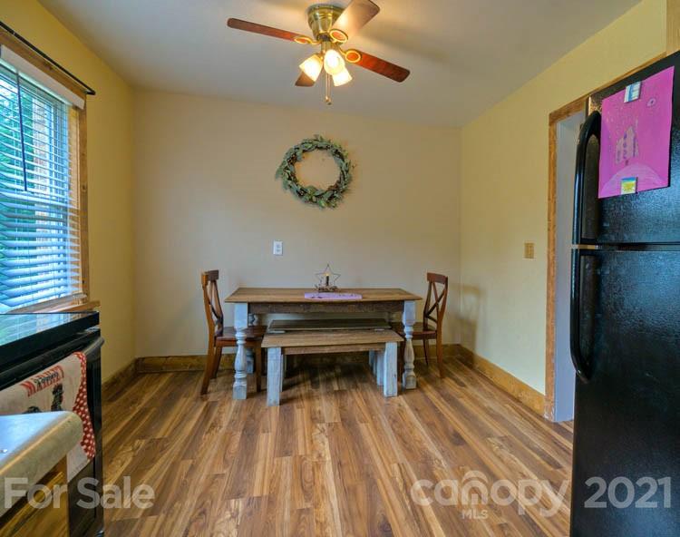 1943 Beaverdam Road Canton, NC 28716 - Photo 6 of 31 a dining room with wooden floor and a chandelier