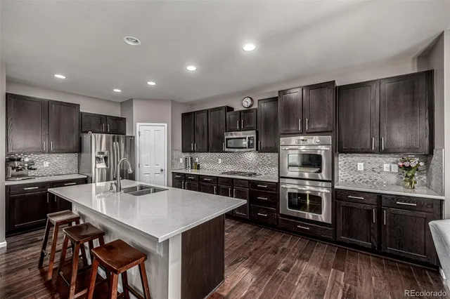 a kitchen with kitchen island granite countertop a sink stove and refrigerator