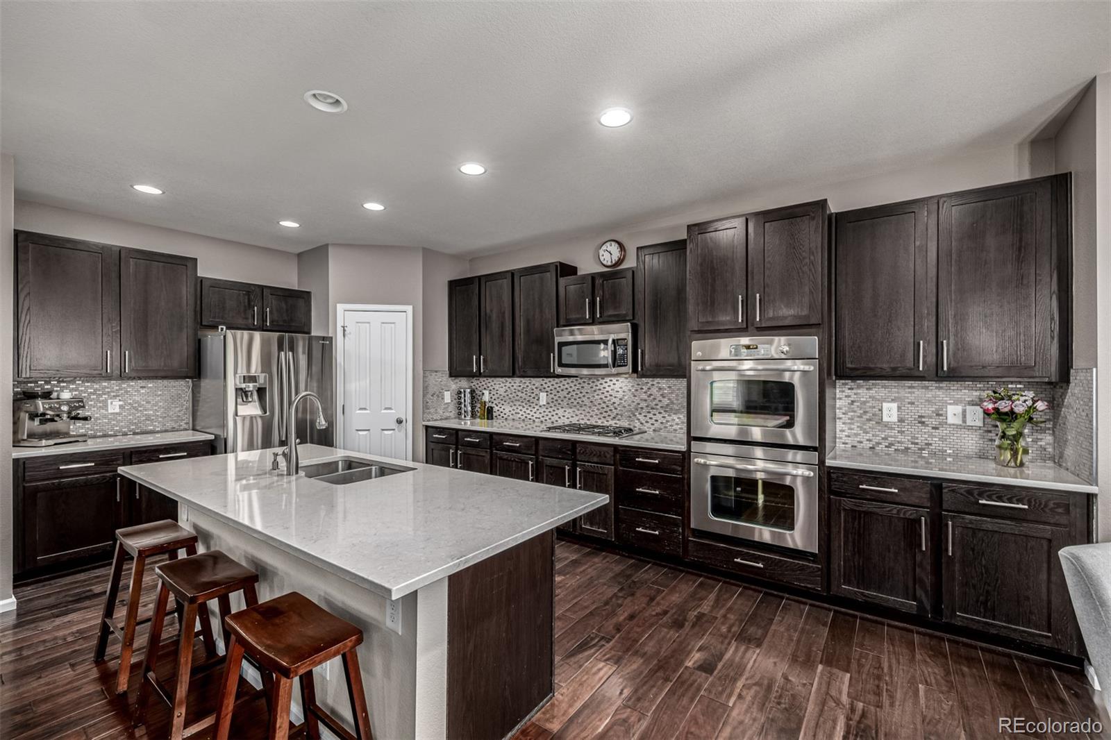 1138 Mircos Street Erie, CO 80516 - Photo 16 of 46 a kitchen with kitchen island granite countertop a sink stove and refrigerator