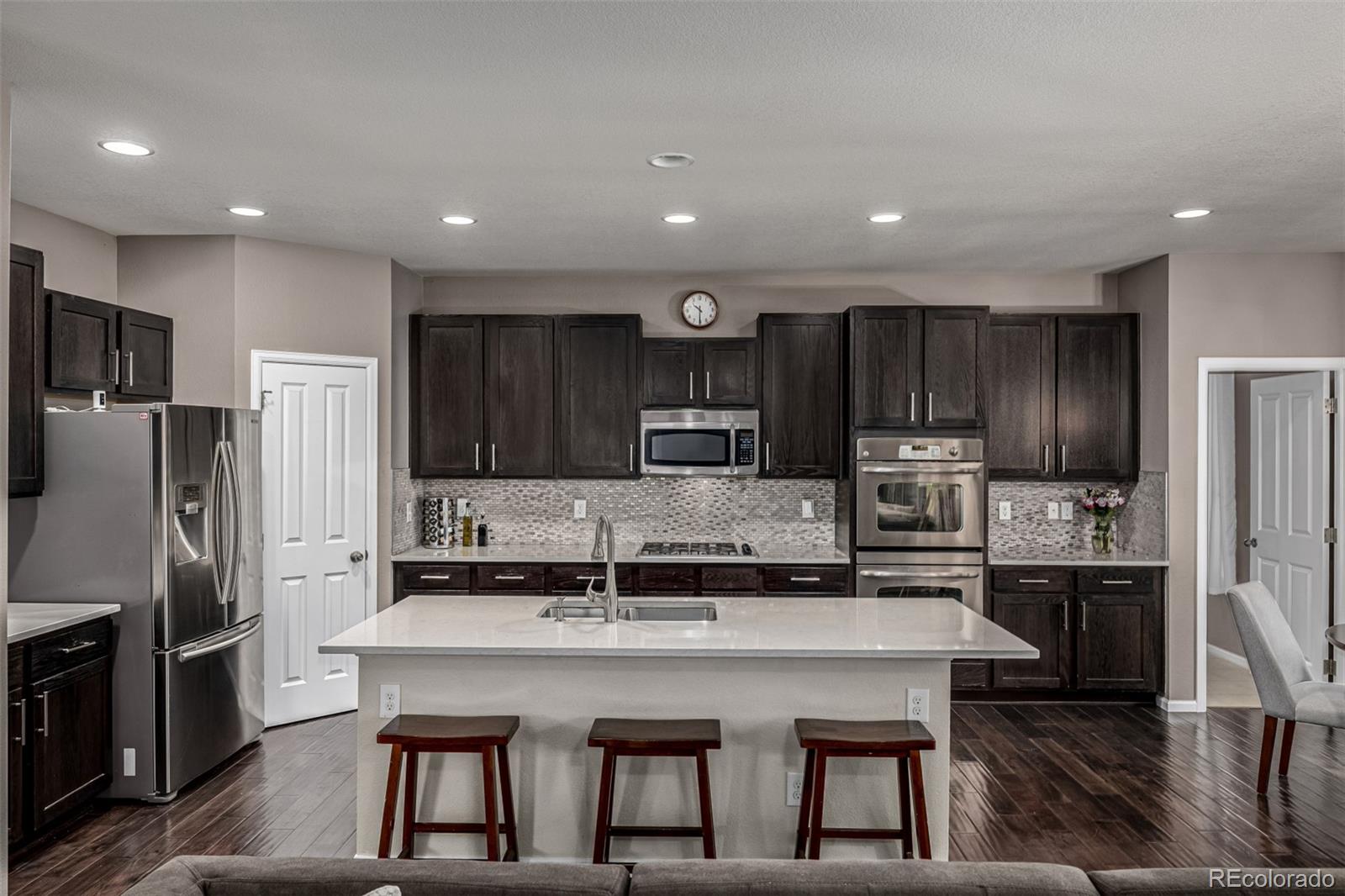 1138 Mircos Street Erie, CO 80516 - Photo 17 of 46 a kitchen with kitchen island a refrigerator and a stove top oven