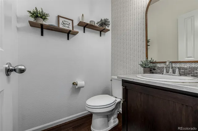 a bathroom with a toilet a sink and mirror