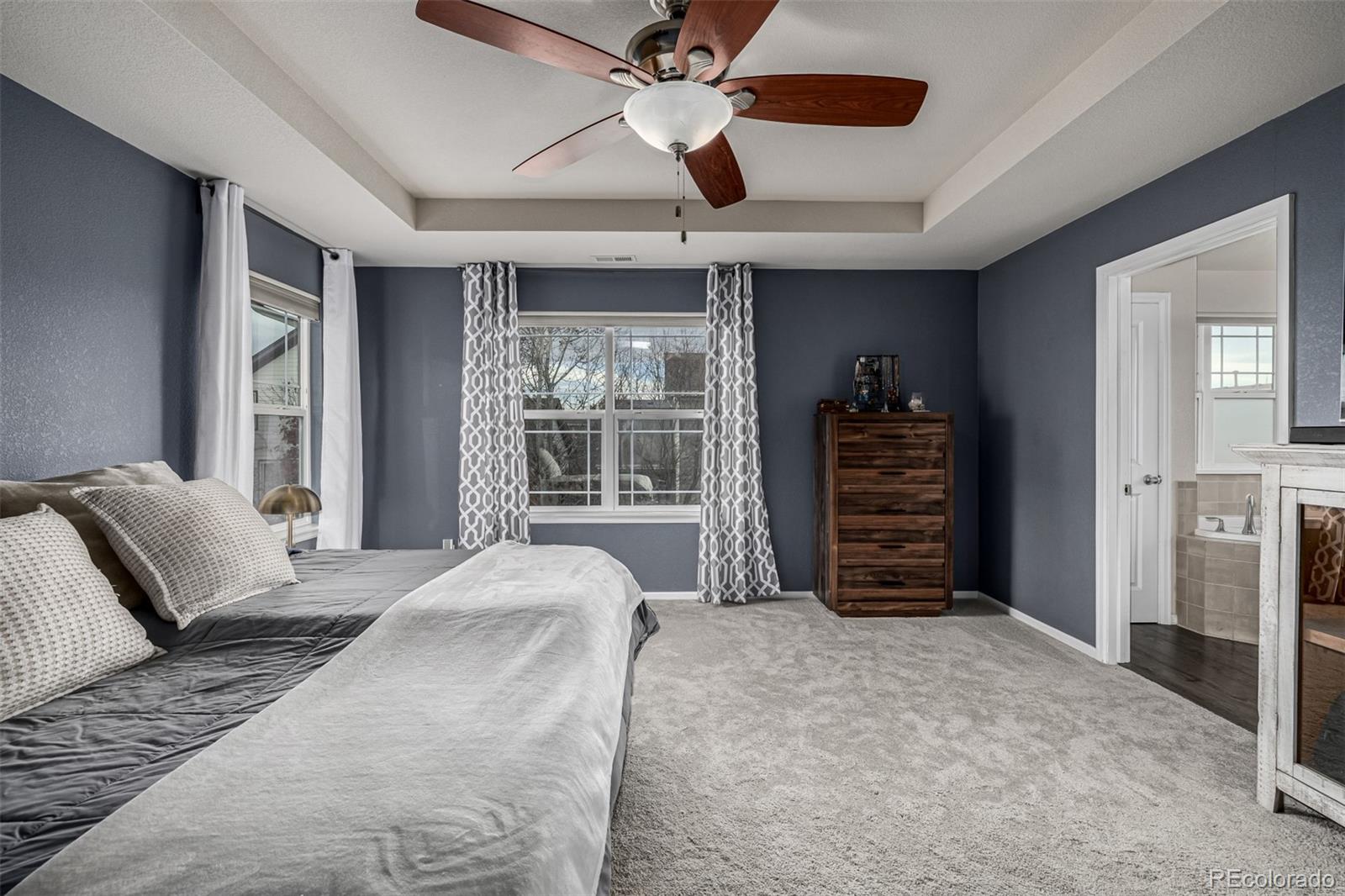 1138 Mircos Street Erie, CO 80516 - Photo 23 of 46 a bedroom with a large bed and a chandelier