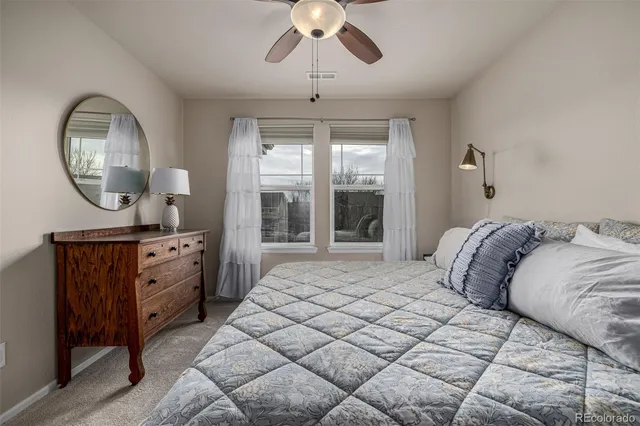 a spacious bedroom with a large bed and a chandelier