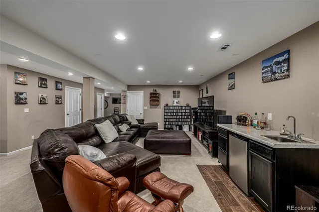 a living room with furniture a rug and kitchen view