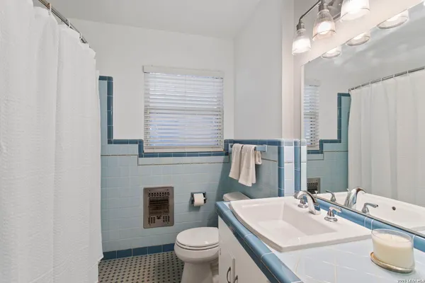 a bathroom with a sink a toilet and a mirror