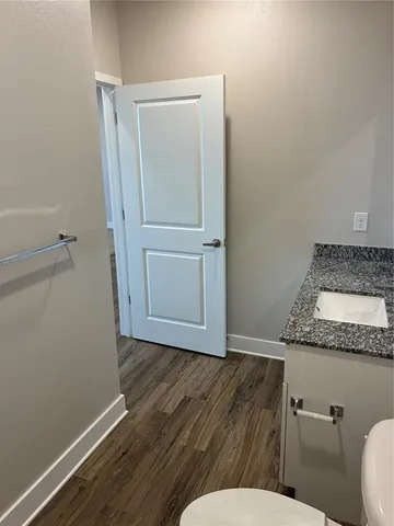 a bathroom with a granite countertop toilet and a sink