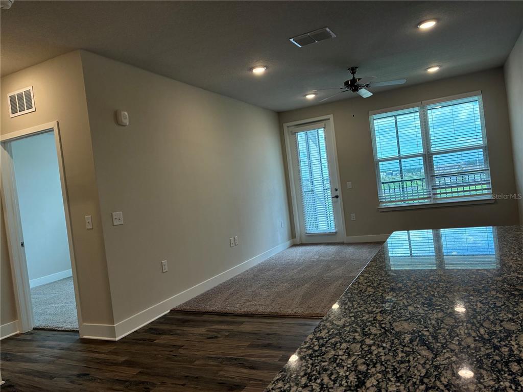 801 Naval Ave Mount, Unit 2203 Mount Dora, FL 32757 - Photo 9 of 16 a view of an empty room with wooden floor and a window