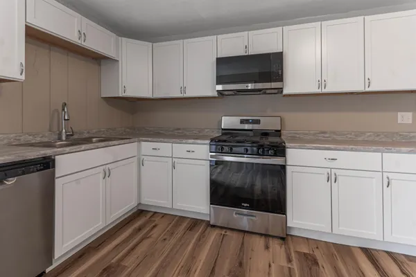 a kitchen with white cabinets stainless steel appliances and sink