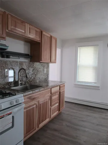 a kitchen with stainless steel appliances granite countertop a stove a sink and white cabinets
