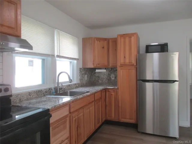 a kitchen with stainless steel appliances granite countertop a refrigerator and a sink