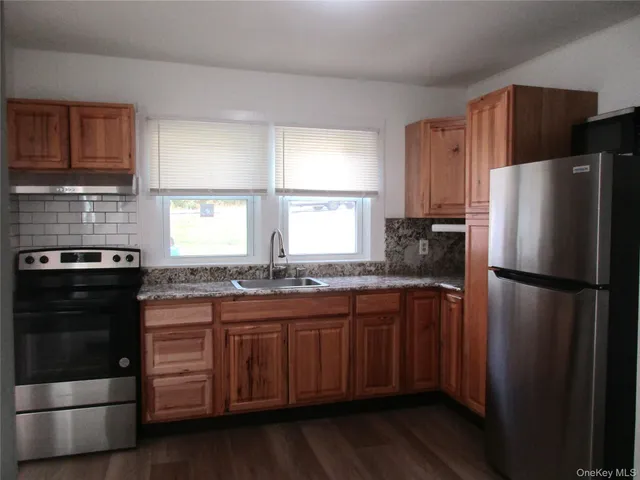 a kitchen with stainless steel appliances granite countertop a refrigerator a stove a sink and a microwave