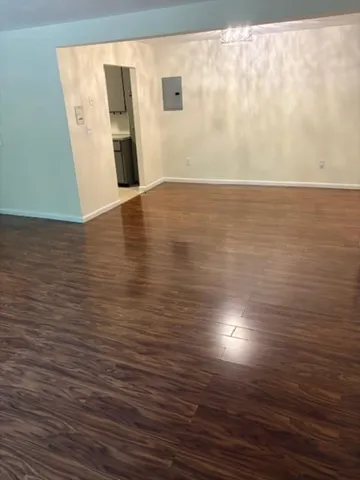 a view of an empty room with wooden floor