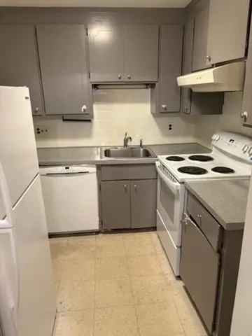 a kitchen with a stove top oven sink and cabinets