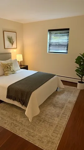 a bedroom with a bed and painting on the wall