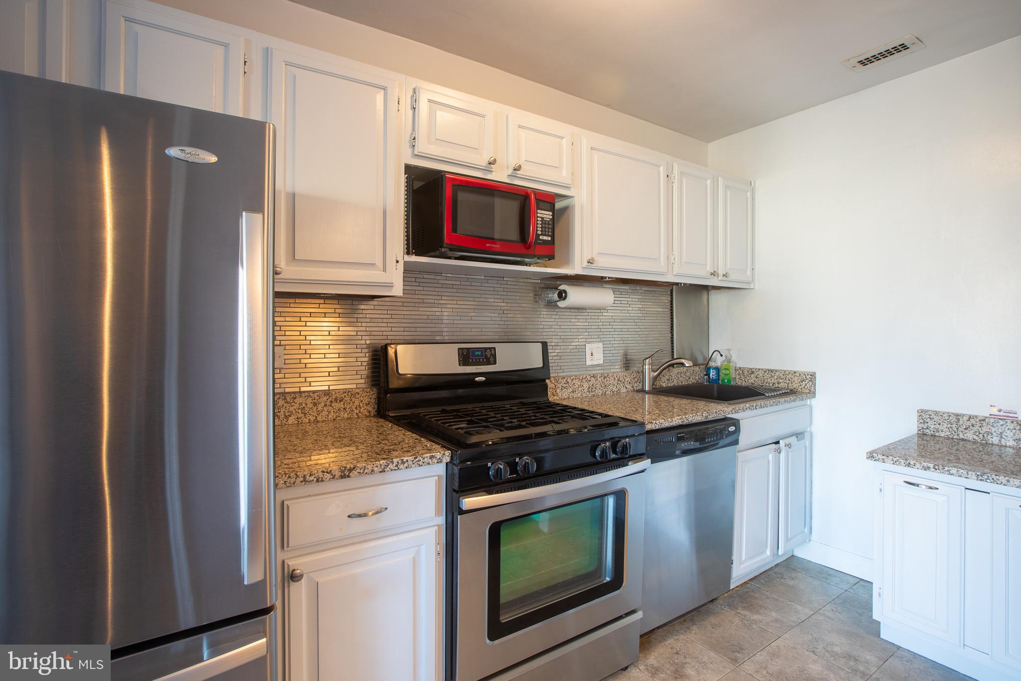 2829 Connecticut Avenue Northwest, Unit 505 Washington, DC 20008 - Photo 11 of 17 a kitchen with stainless steel appliances granite countertop a stove a microwave and a refrigerator