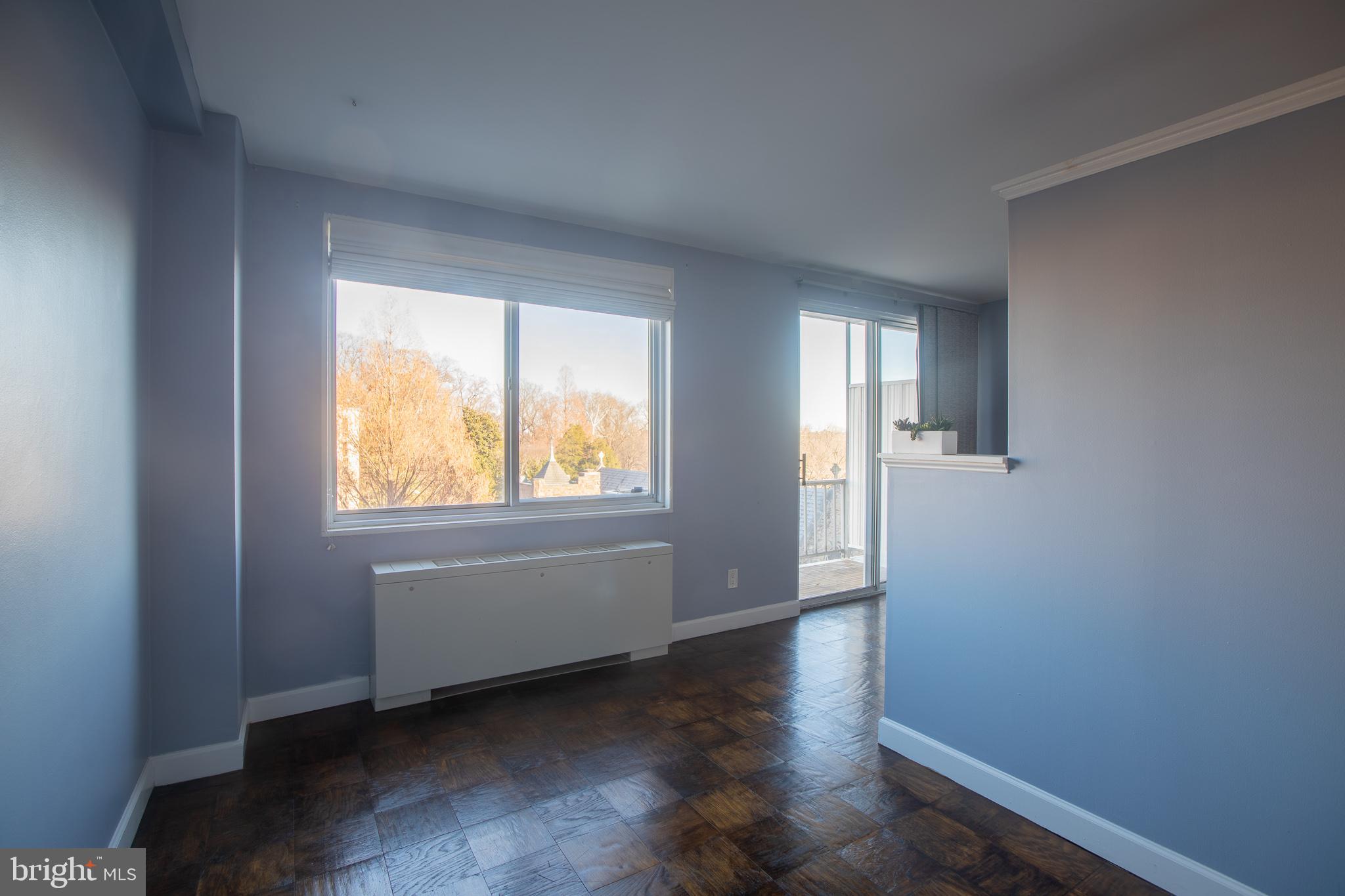 2829 Connecticut Avenue Northwest, Unit 505 Washington, DC 20008 - Photo 6 of 17 an empty room with wooden floor and windows