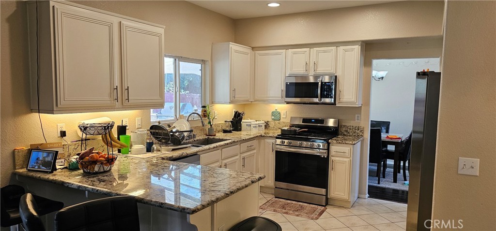 1650 Ravenswood Road Beaumont, CA 92223 - Photo 11 of 42 a kitchen with a stove a sink and a microwave