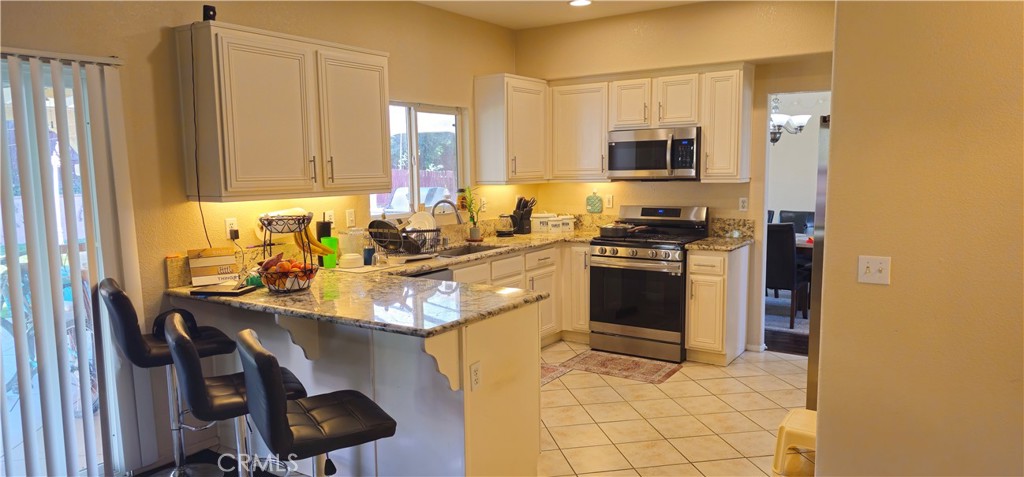 1650 Ravenswood Road Beaumont, CA 92223 - Photo 12 of 42 a kitchen with a sink appliances and cabinets