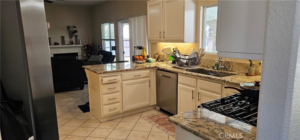 1650 Ravenswood Road Beaumont, CA 92223 - Photo 13 of 42 a kitchen with stainless steel appliances a sink stove and cabinets