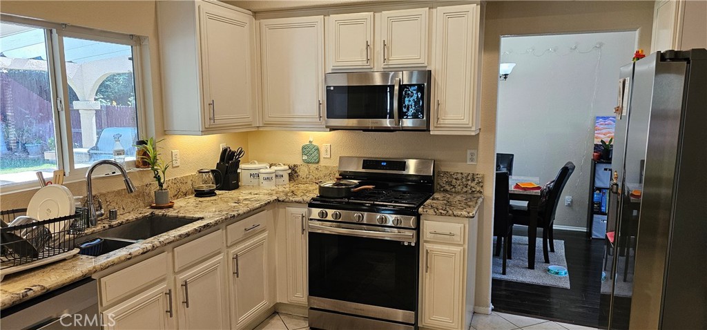 1650 Ravenswood Road Beaumont, CA 92223 - Photo 15 of 42 a kitchen with stainless steel appliances granite countertop a stove a sink and a refrigerator