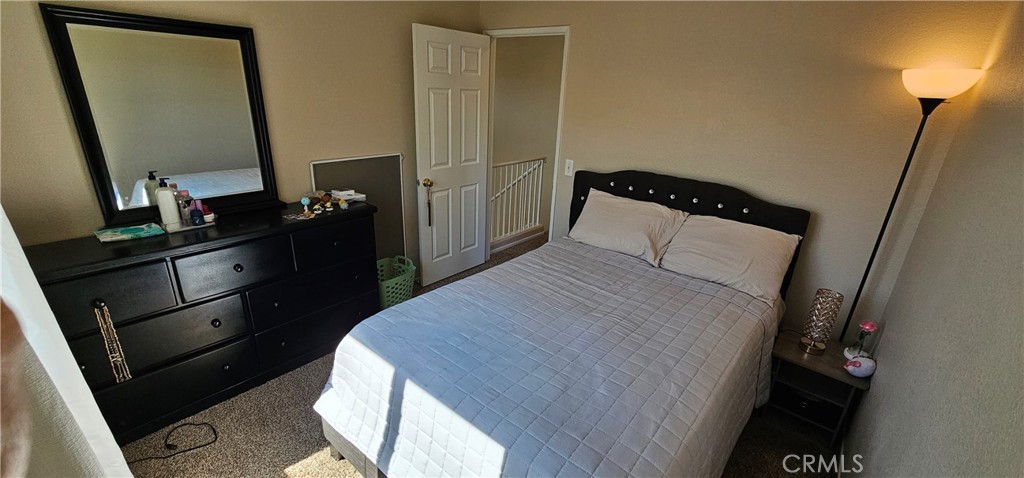 1650 Ravenswood Road Beaumont, CA 92223 - Photo 23 of 42 a bedroom with a bed and a mirror on dresser