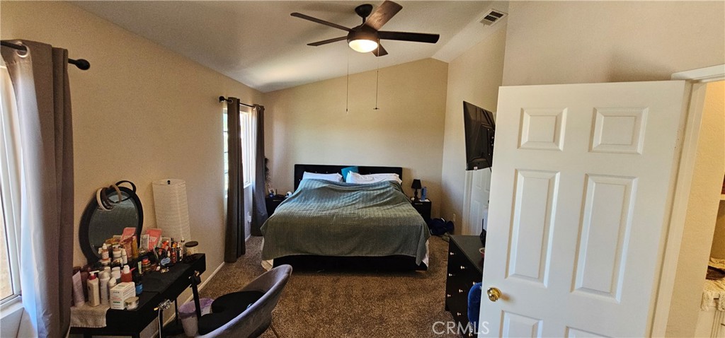 1650 Ravenswood Road Beaumont, CA 92223 - Photo 27 of 42 a bedroom with a bed and a chandelier