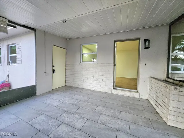 a view of a hallway with wooden floor and a living room
