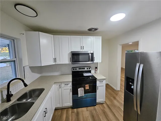 a kitchen with stainless steel appliances a stove a sink a refrigerator and cabinets