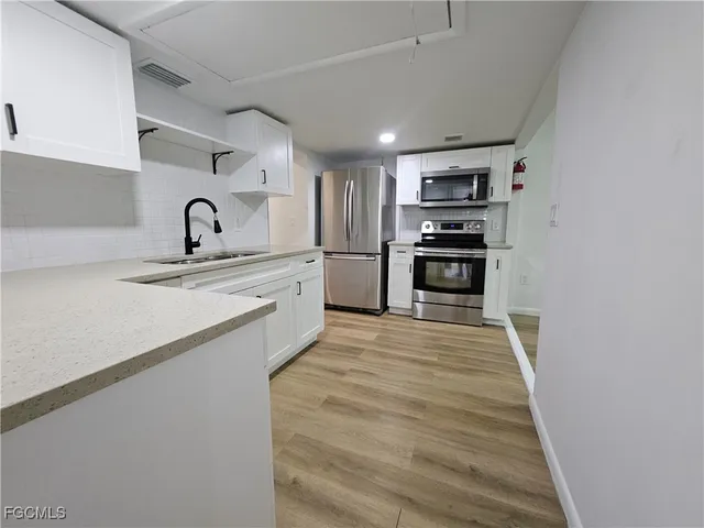 a kitchen with granite countertop a sink and steel appliances