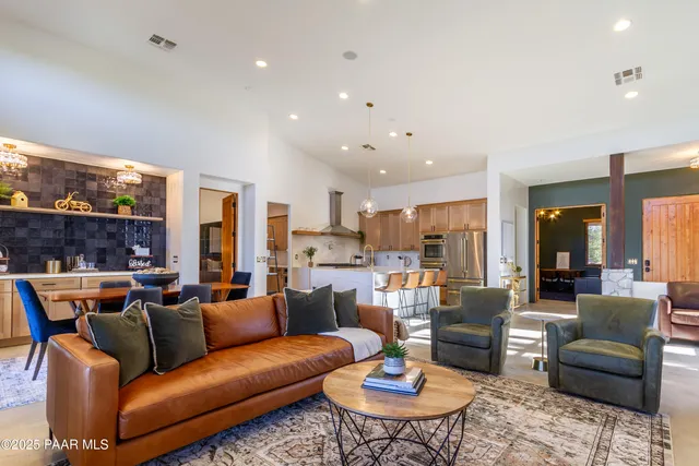 a living room with furniture kitchen view and a large window