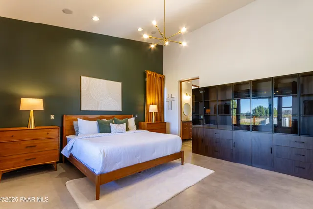 a bedroom with a large bed and a chandelier