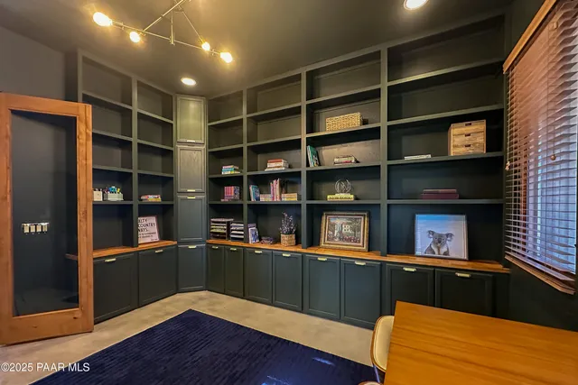 a room with lots of wooden furniture and a window