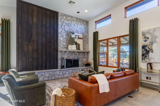 a living room with furniture fireplace and large window