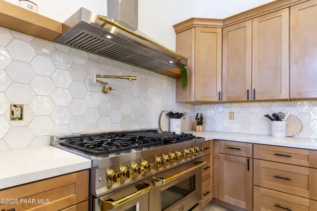a kitchen with a stove and white cabinets