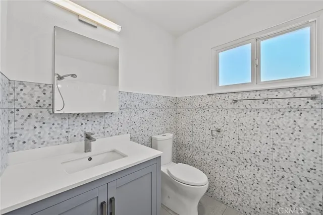 a bathroom with a sink a toilet and mirror