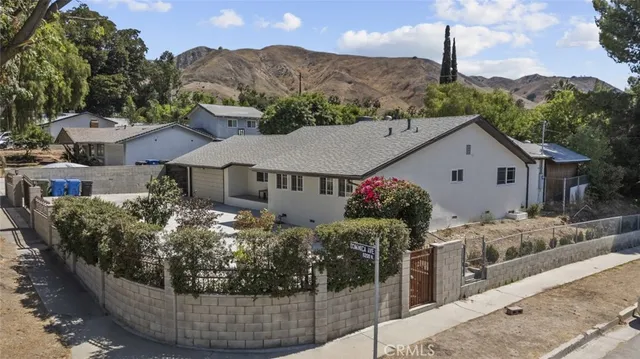 a view of a house with backyard and sitting area