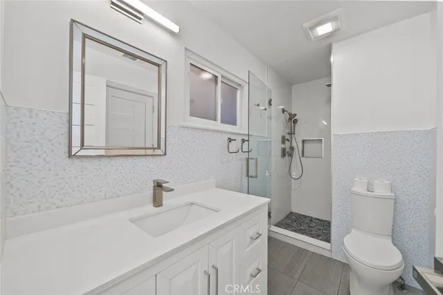 a bathroom with a sink toilet vanity and shower