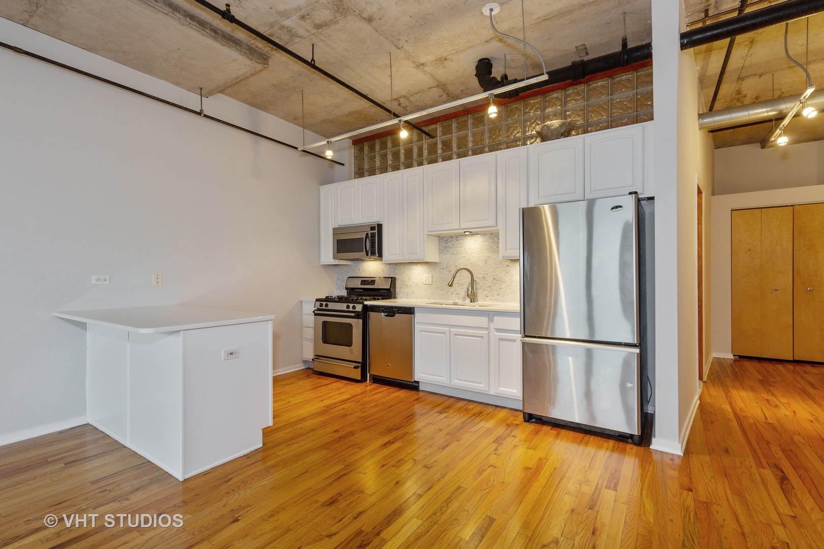 6 South Laflin Street, Unit 807S Chicago, IL 60607 - Photo 2 of 18 a kitchen with granite countertop a refrigerator and wooden floor
