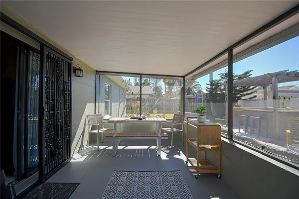 a living room with couch tv and a floor to ceiling window