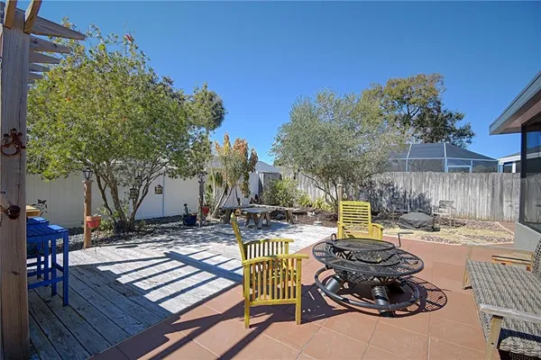 a view of patio with table and chairs potted plants and palm tree
