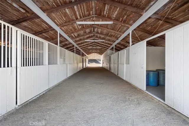 a kitchen with granite countertop a refrigerator a sink dishwasher a stove and white countertops with wooden floor