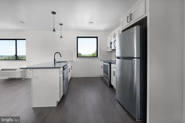 a kitchen with a refrigerator a sink and cabinets