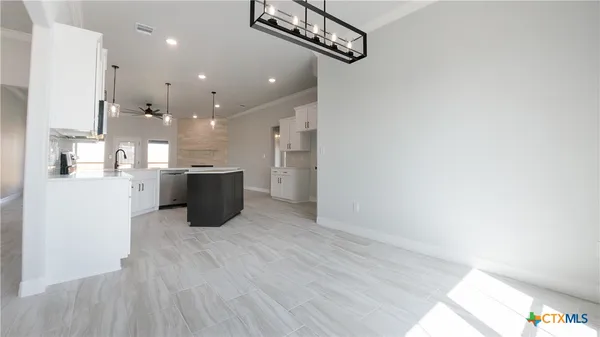 a open kitchen with a refrigerator and a microwave