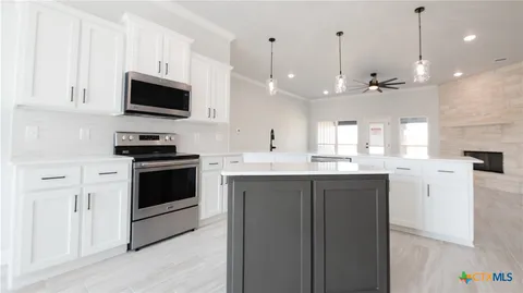 a large white kitchen with stainless steel appliances