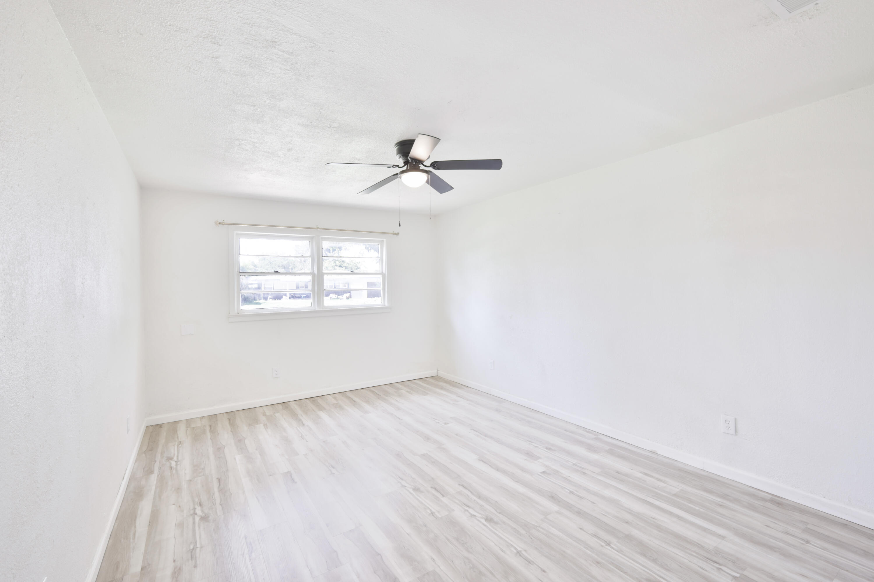 3812 31st Street Lubbock, TX 79410 - Photo 8 of 16 an empty room with wooden floor and ceiling fan