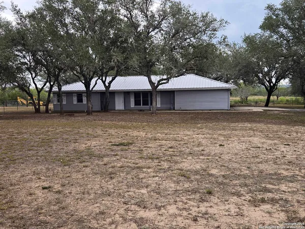 a front view of a house with yard and trees
