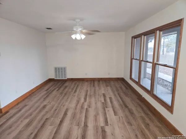 a view of empty room with wooden floor